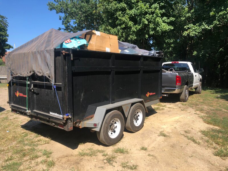 Picture of a junk removal service truck. You can see on the picture that the truck is hauling away all the junk in a trailer. 
