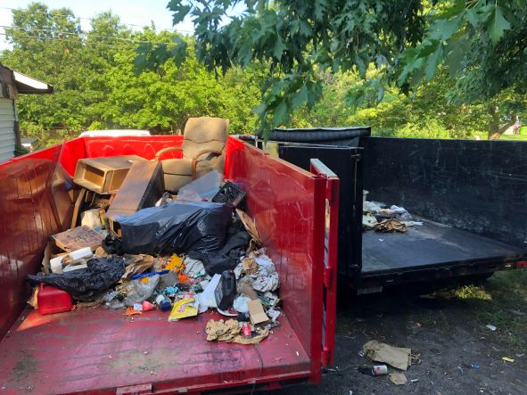 Picture of two dumpster unit that have been rented out. You can see that they are being used to collect any type of trash, dirt or construction material. 
