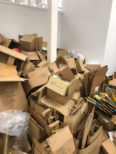 Picture of a room in the a store in Suffolk County full of cardboard boxes. A junk removal service is hired to clean out all of it.